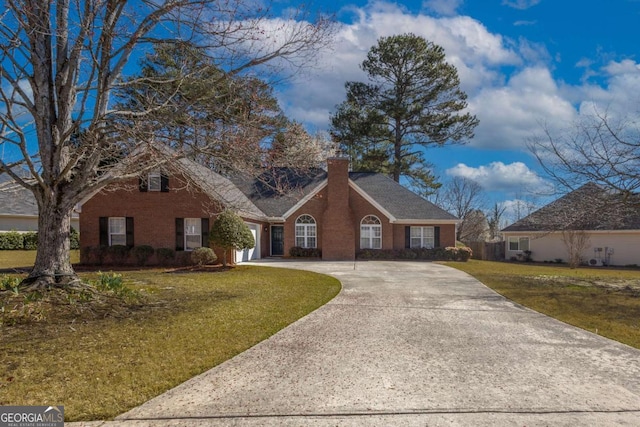 view of front of property featuring brick siding, a front yard, a chimney, a garage, and driveway