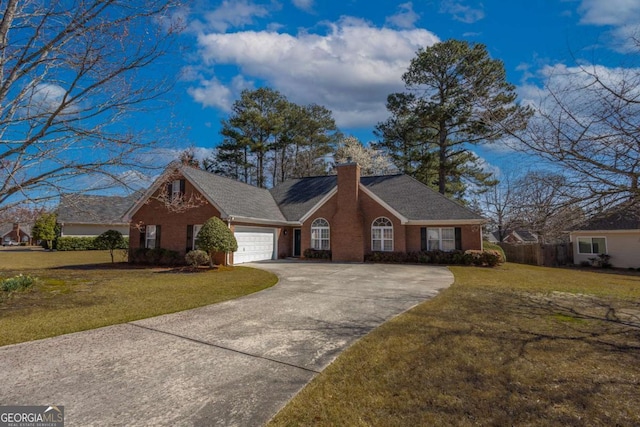 view of front of home with brick siding, a garage, a front lawn, and a chimney