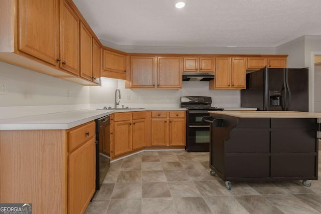 kitchen with a sink, black appliances, light countertops, under cabinet range hood, and crown molding