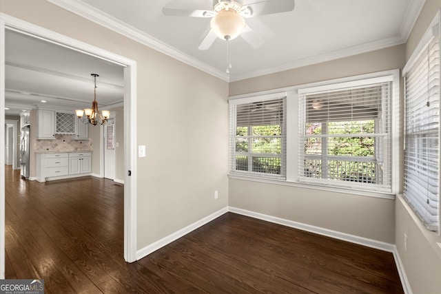 spare room with baseboards, dark wood-style floors, crown molding, and ceiling fan with notable chandelier