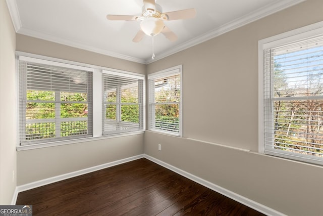 spare room featuring ornamental molding, ceiling fan, baseboards, and dark wood-style flooring