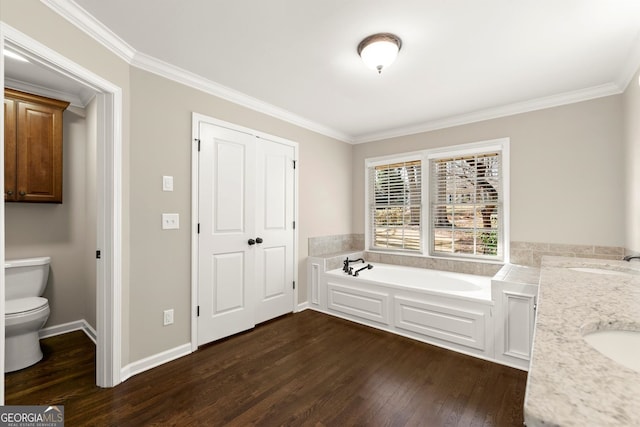 bathroom featuring toilet, crown molding, a garden tub, and wood finished floors