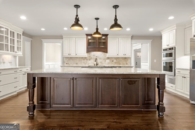 kitchen featuring a warming drawer, stainless steel appliances, and white cabinetry