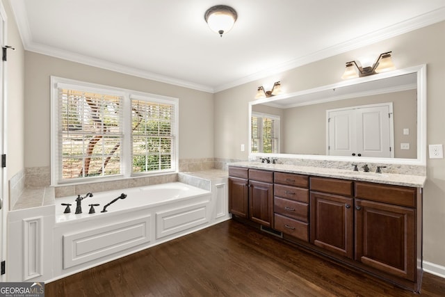 bathroom featuring a garden tub, wood finished floors, and a sink