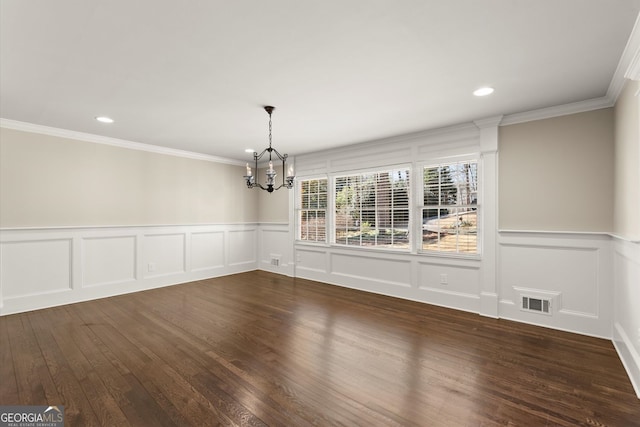 unfurnished dining area with crown molding, a notable chandelier, dark wood-style floors, and visible vents