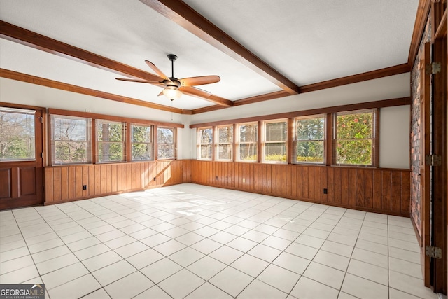 unfurnished sunroom featuring beam ceiling, a healthy amount of sunlight, and a ceiling fan