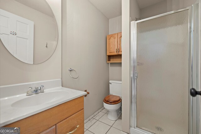 full bathroom featuring vanity, tile patterned floors, toilet, and a shower stall