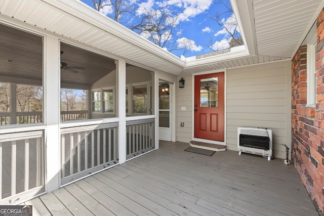 deck featuring heating unit and a sunroom