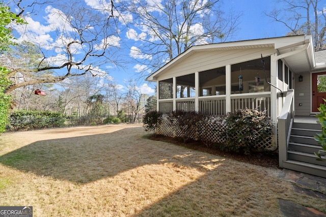 view of yard featuring fence and a sunroom