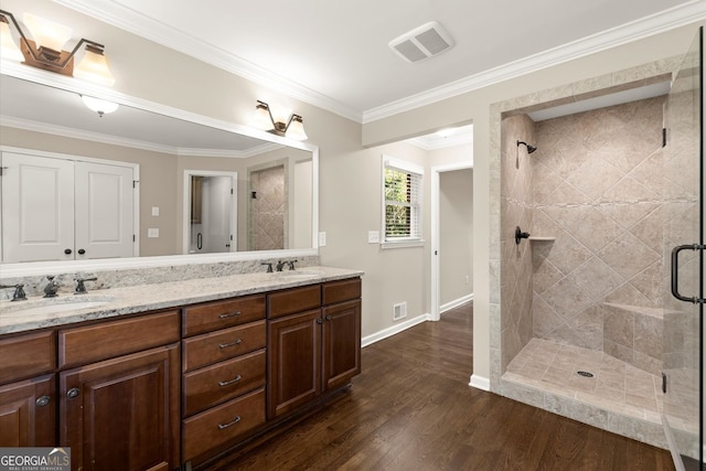 full bathroom with visible vents, a stall shower, wood finished floors, and a sink