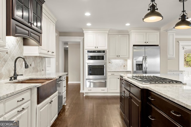 kitchen featuring dark brown cabinets, glass insert cabinets, stainless steel appliances, white cabinetry, and a warming drawer