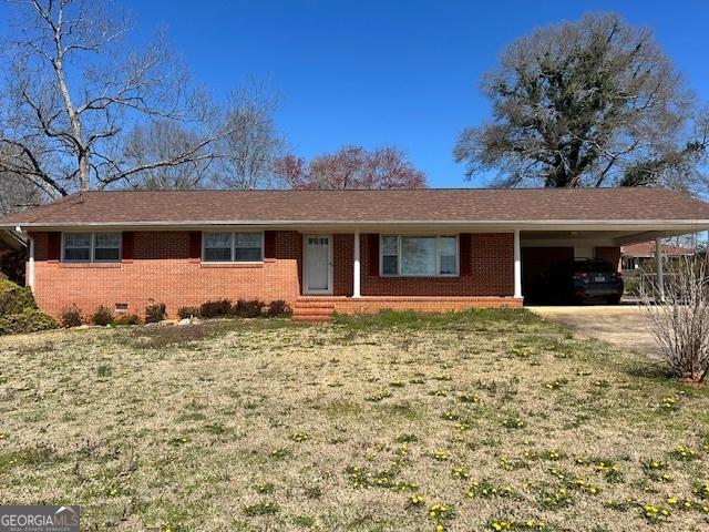 ranch-style home featuring a carport, crawl space, brick siding, and driveway