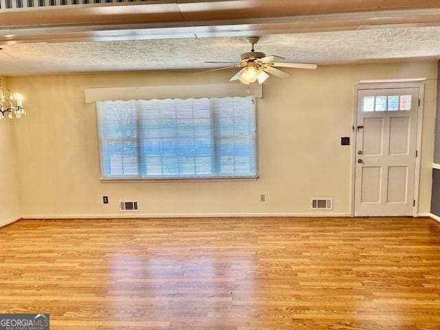 entrance foyer with visible vents, a healthy amount of sunlight, and wood finished floors