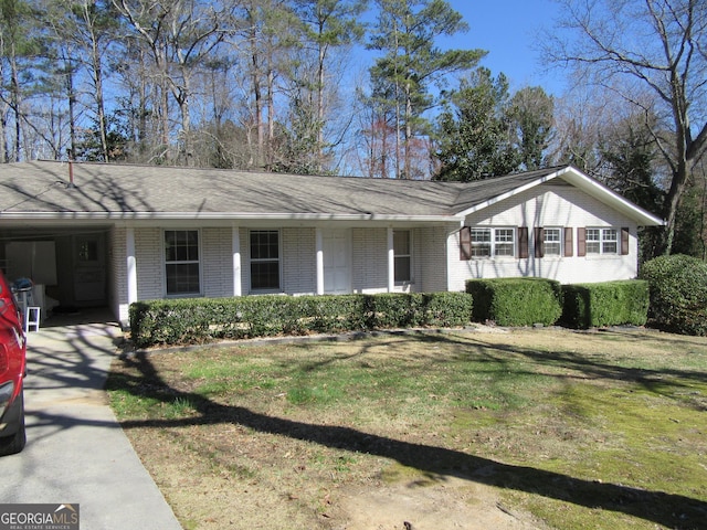 view of front of home featuring a carport, brick siding, and a front yard