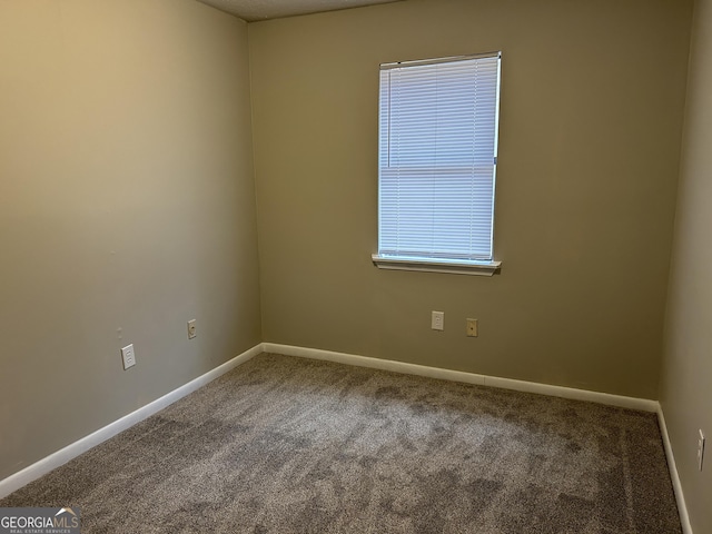 carpeted empty room with baseboards