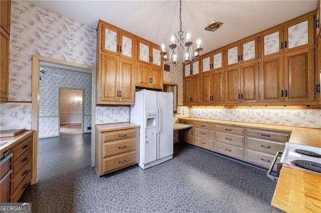 kitchen with wallpapered walls, glass insert cabinets, decorative light fixtures, a chandelier, and white refrigerator with ice dispenser