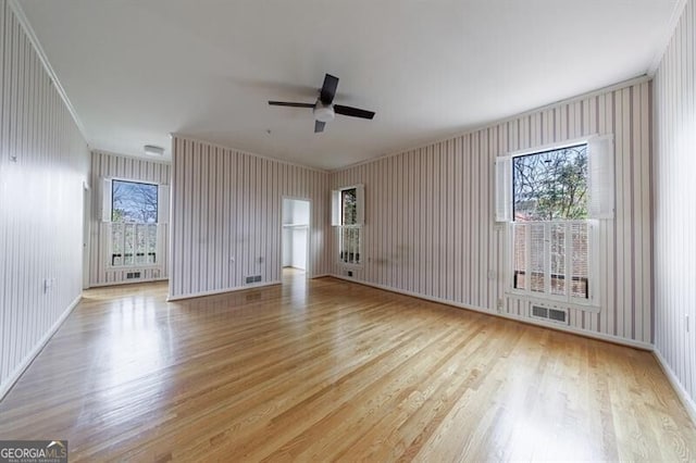 unfurnished room featuring visible vents, wood finished floors, and a ceiling fan