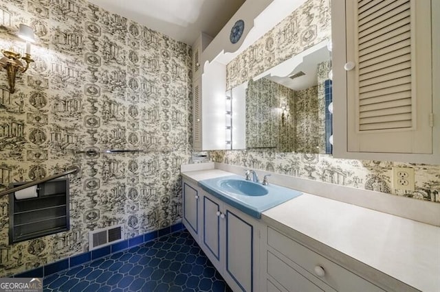 bathroom featuring wallpapered walls, vanity, and visible vents