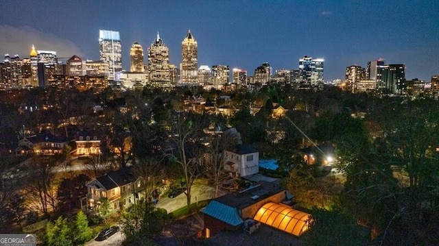 aerial view at twilight featuring a view of city lights