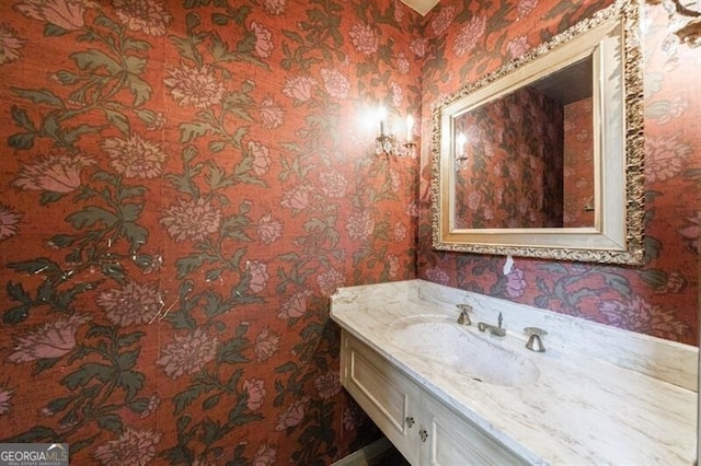 bathroom with wallpapered walls and vanity