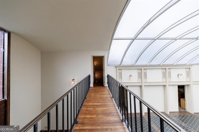 hallway featuring lofted ceiling and wood finished floors