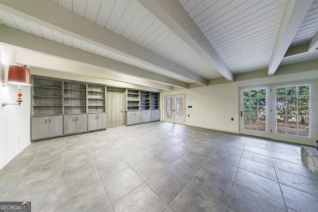 unfurnished living room featuring tile patterned floors, baseboards, and beam ceiling