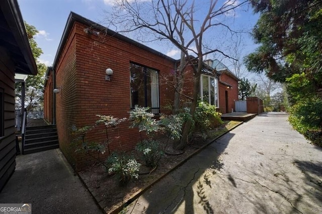 view of home's exterior featuring brick siding and a gate