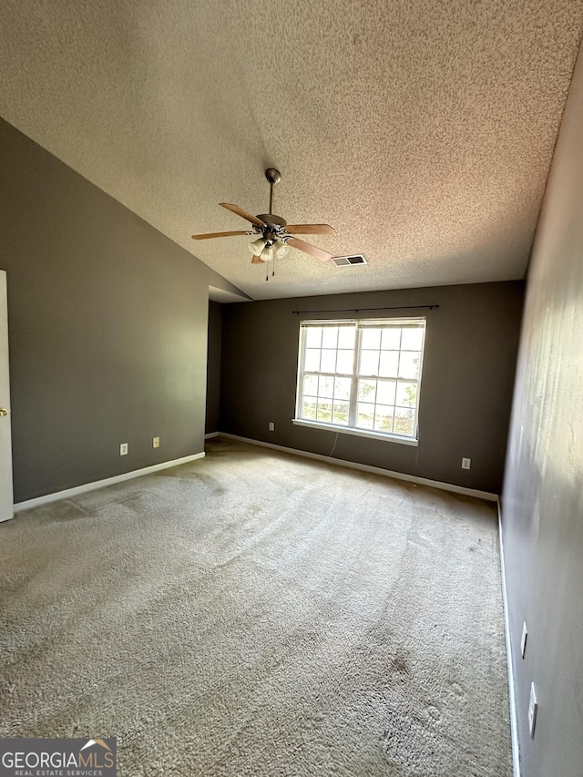 carpeted empty room with visible vents, baseboards, a textured ceiling, and a ceiling fan