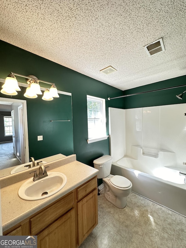 bathroom with vanity, toilet, visible vents, and a textured ceiling