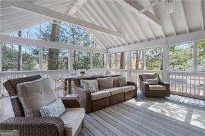 sunroom / solarium with vaulted ceiling with beams