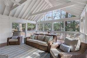 sunroom / solarium featuring lofted ceiling with beams