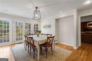 dining room with ornamental molding, baseboards, and wood finished floors