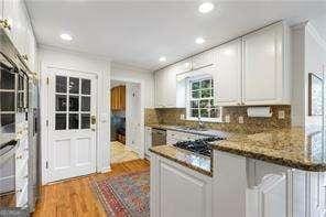 kitchen featuring light wood-style flooring, tasteful backsplash, recessed lighting, white cabinets, and light stone countertops