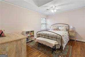 bedroom featuring baseboards, ceiling fan, and wood finished floors