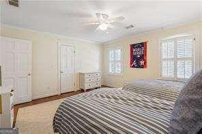 bedroom featuring multiple windows, wood finished floors, and baseboards