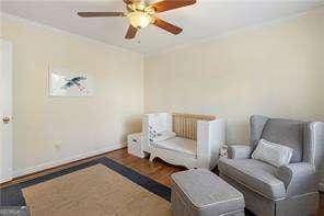 living area with a ceiling fan, wood finished floors, and baseboards