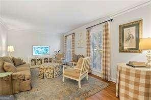 living area featuring wood finished floors and ornamental molding