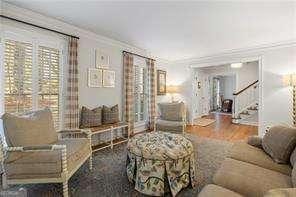 living room featuring stairs, crown molding, and wood finished floors