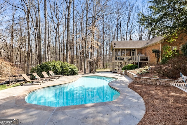 outdoor pool featuring stairway and a patio area