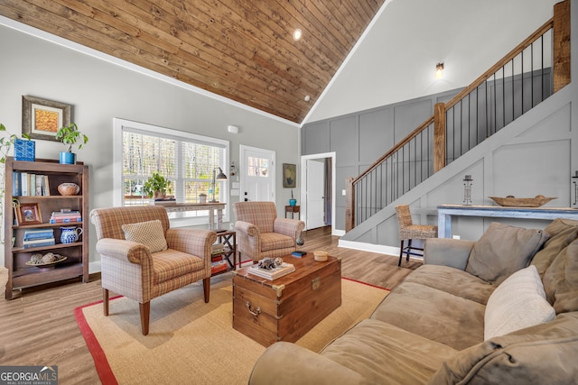 living room featuring light wood finished floors, high vaulted ceiling, stairs, crown molding, and wooden ceiling