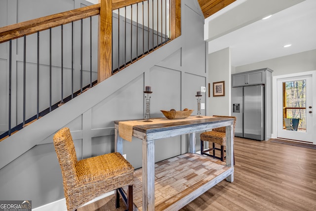 stairway with recessed lighting, wood finished floors, and a decorative wall