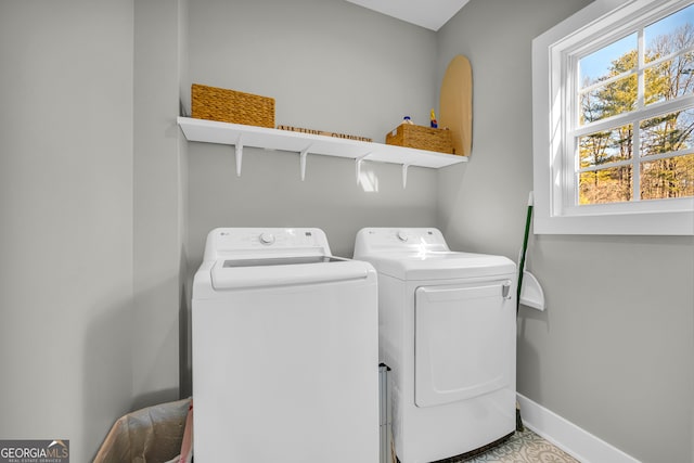 washroom with washer and dryer, laundry area, and baseboards