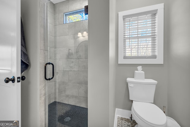 full bathroom featuring baseboards, toilet, and a shower stall