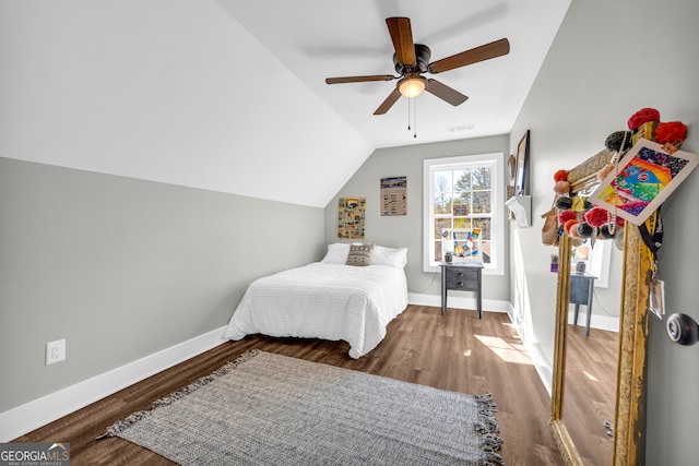 bedroom featuring visible vents, baseboards, vaulted ceiling, wood finished floors, and a ceiling fan