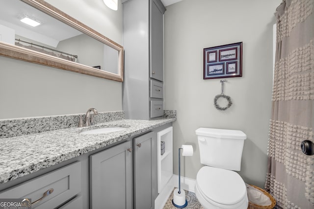 bathroom with vanity, toilet, and baseboards