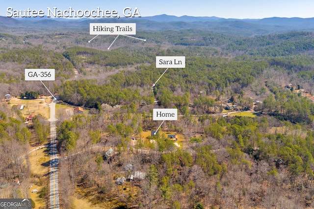 drone / aerial view featuring a mountain view and a view of trees