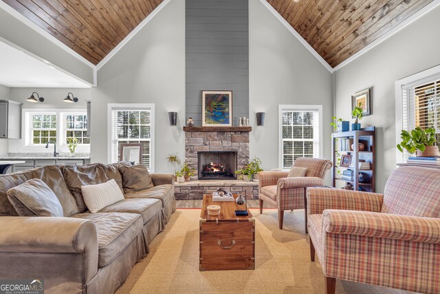 living area featuring a fireplace, high vaulted ceiling, wood ceiling, and ornamental molding