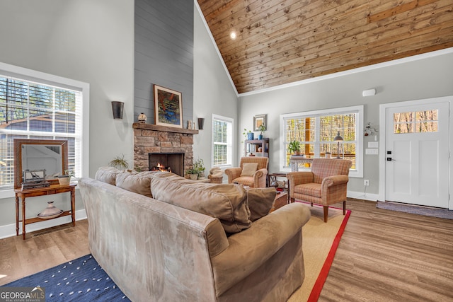 living area with a fireplace, high vaulted ceiling, baseboards, and wood finished floors