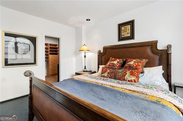 bedroom with a closet, baseboards, and a spacious closet