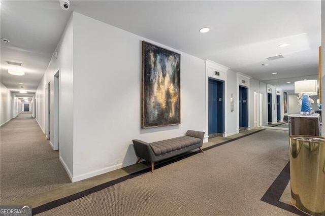 corridor featuring elevator, carpet, and baseboards